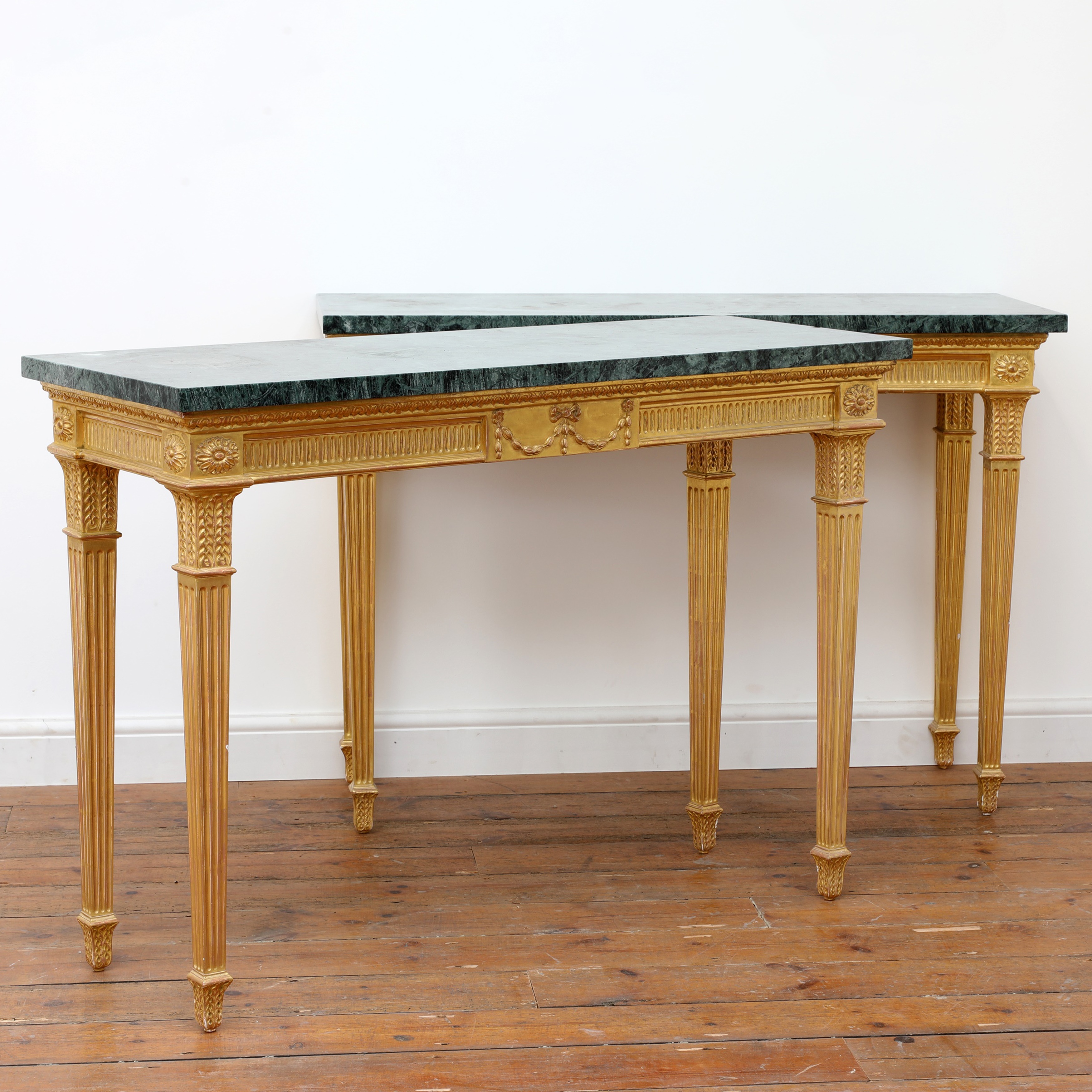 A pair of giltwood console tables in the manner of Robert Adam